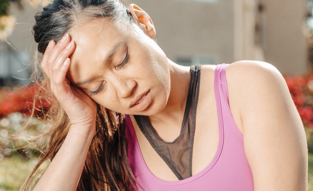 Nahaufnahme einer Frau, die ihr Gesicht vor Schmerzen verzieht