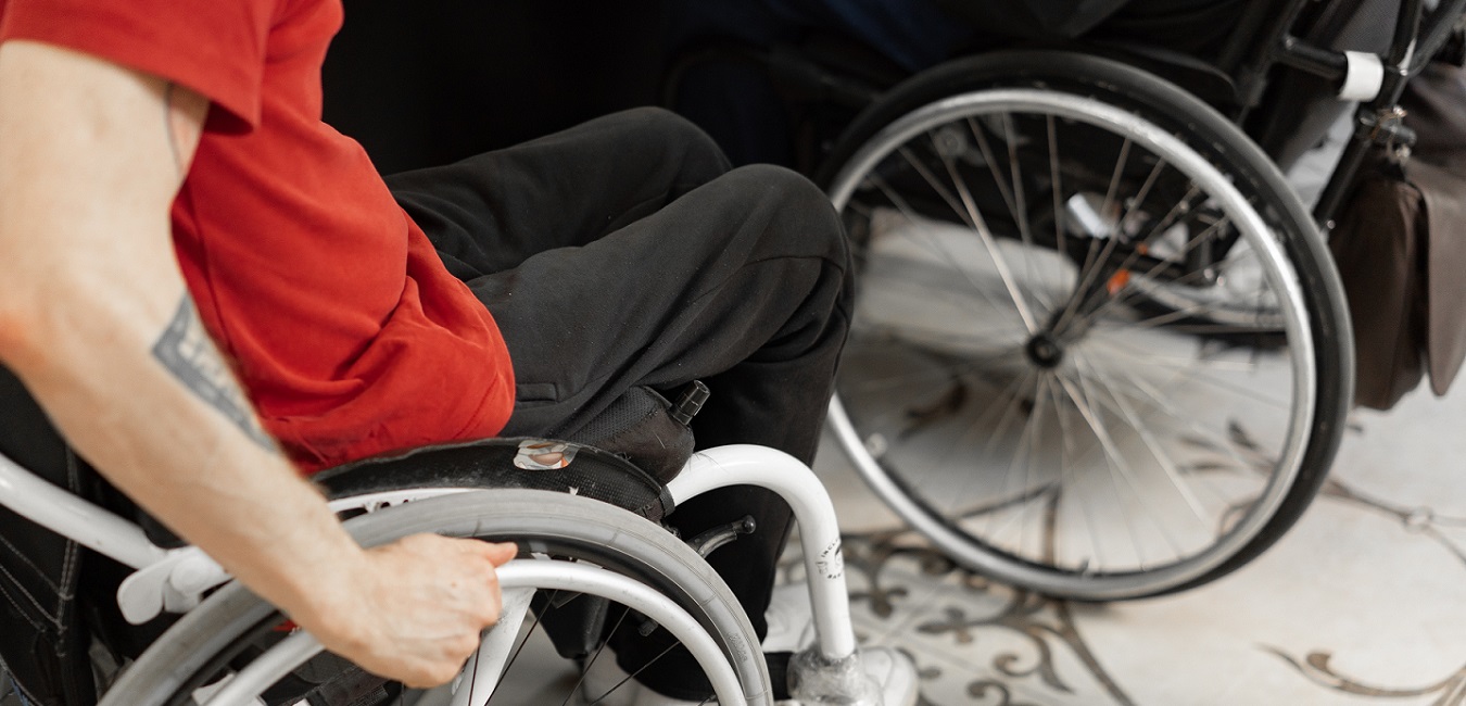 Tätowierte Person mit MS im Rollstuhl