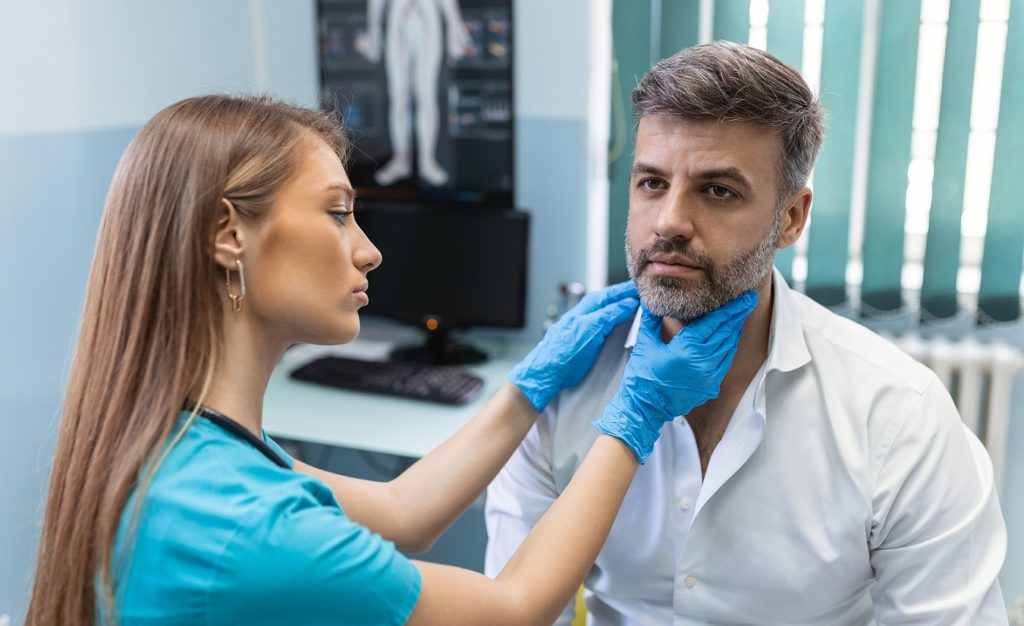 Nahaufnahme eines Therapeuten und eines MS-Patienten, die in einem Beratungsgespräch für Schluckstörungen engagiert sind.