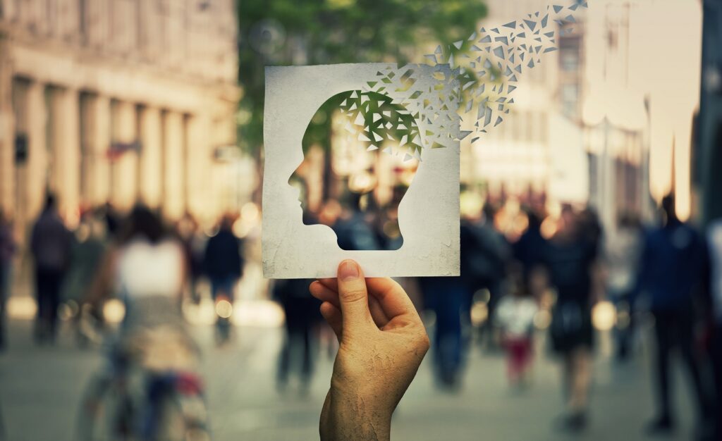 Ein trauriger Blick auf ein menschliches Gehirnmodell mit einem Puzzlestück, das herausfällt - eine metaphorische Darstellung der Multiplen Sklerose und kognitiver Störungen.