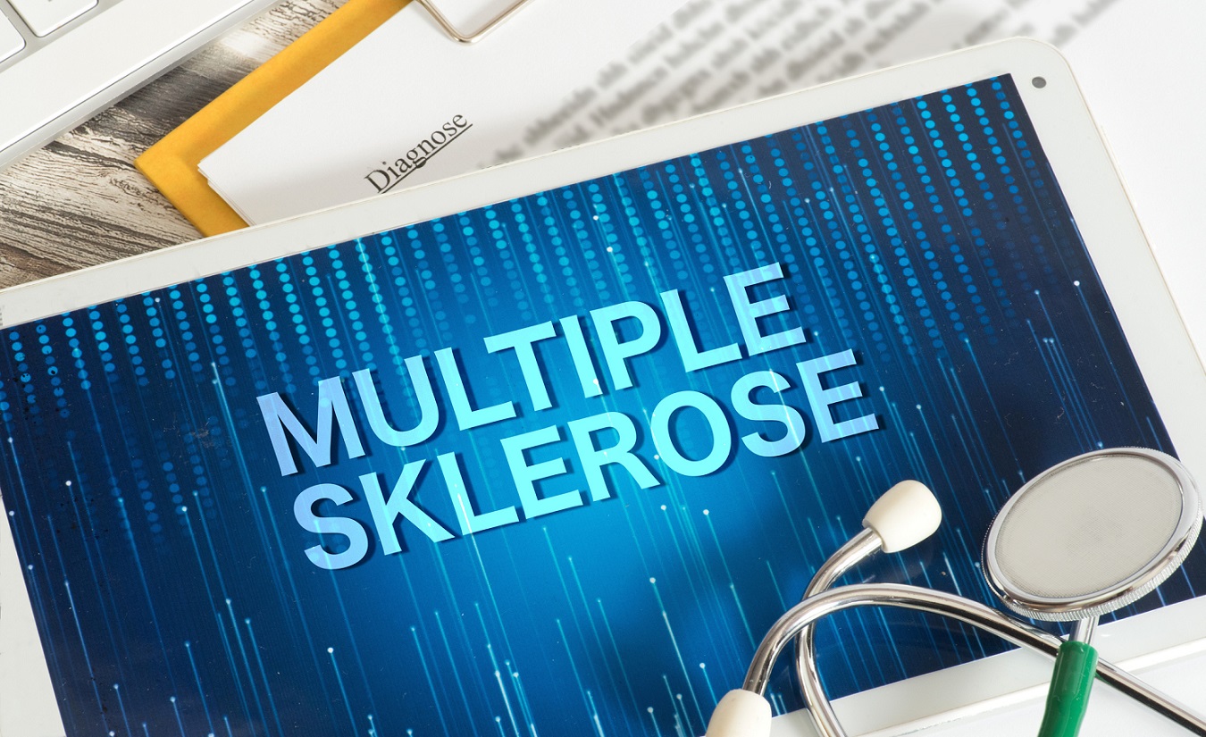 Ein Symbolbild für die Diagnose und verschiedene Verlaufsformen der Multiplen Sklerose (MS). Das Bild zeigt einen Tablet-PC, ein Stethoskop, eine Tastatur und einen Diagnose-Zettel.