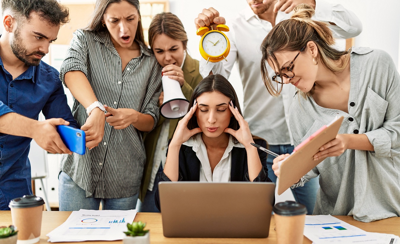 Eine Gruppe gestresster Geschäftsleute, die sich gegenseitig im Büro anschreien.