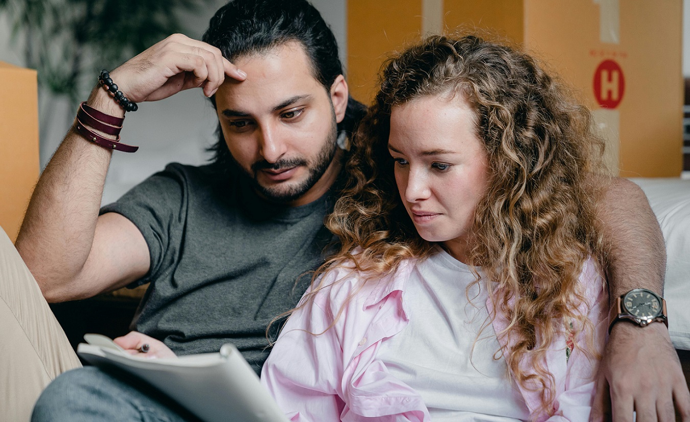 Ein Mann und eine Frau überprüfen gemeinsam eine Checkliste, die symbolisch für eine To-Do-Liste nach einer MS-Diagnose steht.