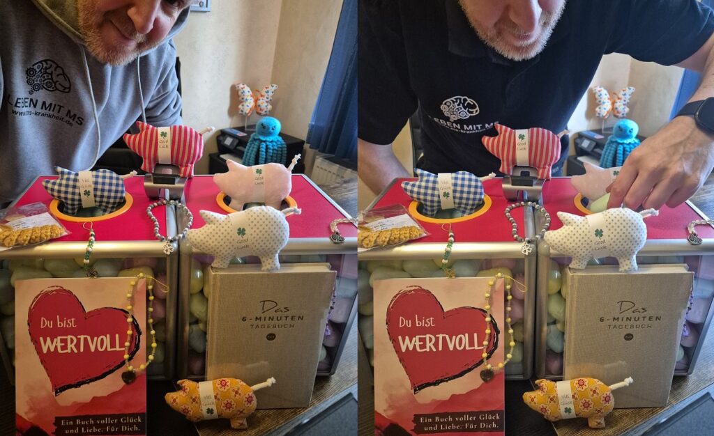 Marco Rickhoff führt sein Good-Vibes-Gewinnspiel durch. Auf dem Schreibtisch stehen zwei Losboxen und verschiedene Preise, darunter zwei Bücher, fünf Glücksschweinchen, ein Glückswürmchen und fünf Anhänger. Er trägt einen grauen Hoodie und ein schwarzes Poloshirt mit dem Logo und Schriftzug seiner MS-Domain.